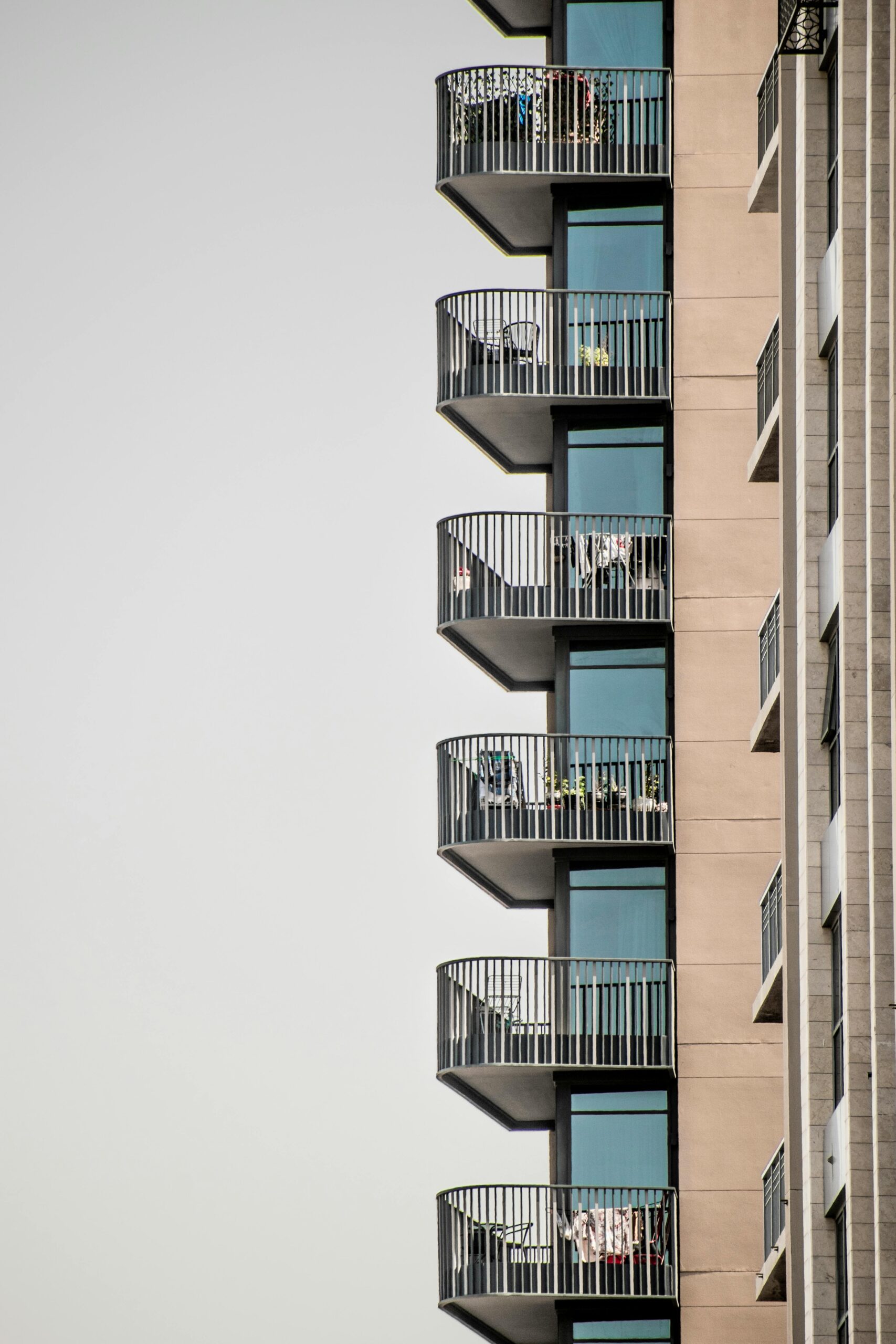 Stylish apartment balconies on a high-rise building in Dubai with a clear sky background.